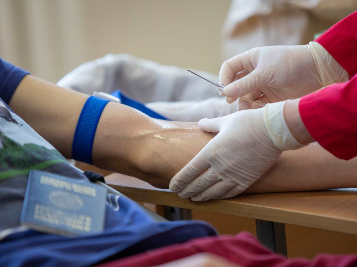 A healthcare professional draws a blood sample from a patient at a clinic
